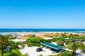 A coastal hotel with beach access, a parking area, and a view of the sea. - Hotel Bencista (Pietrasanta)