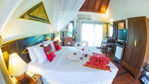 A hotel room with a large bed, a bedside telephone, a lamp, and a wardrobe. - Golden Pine Resort (Chiang Rai)
