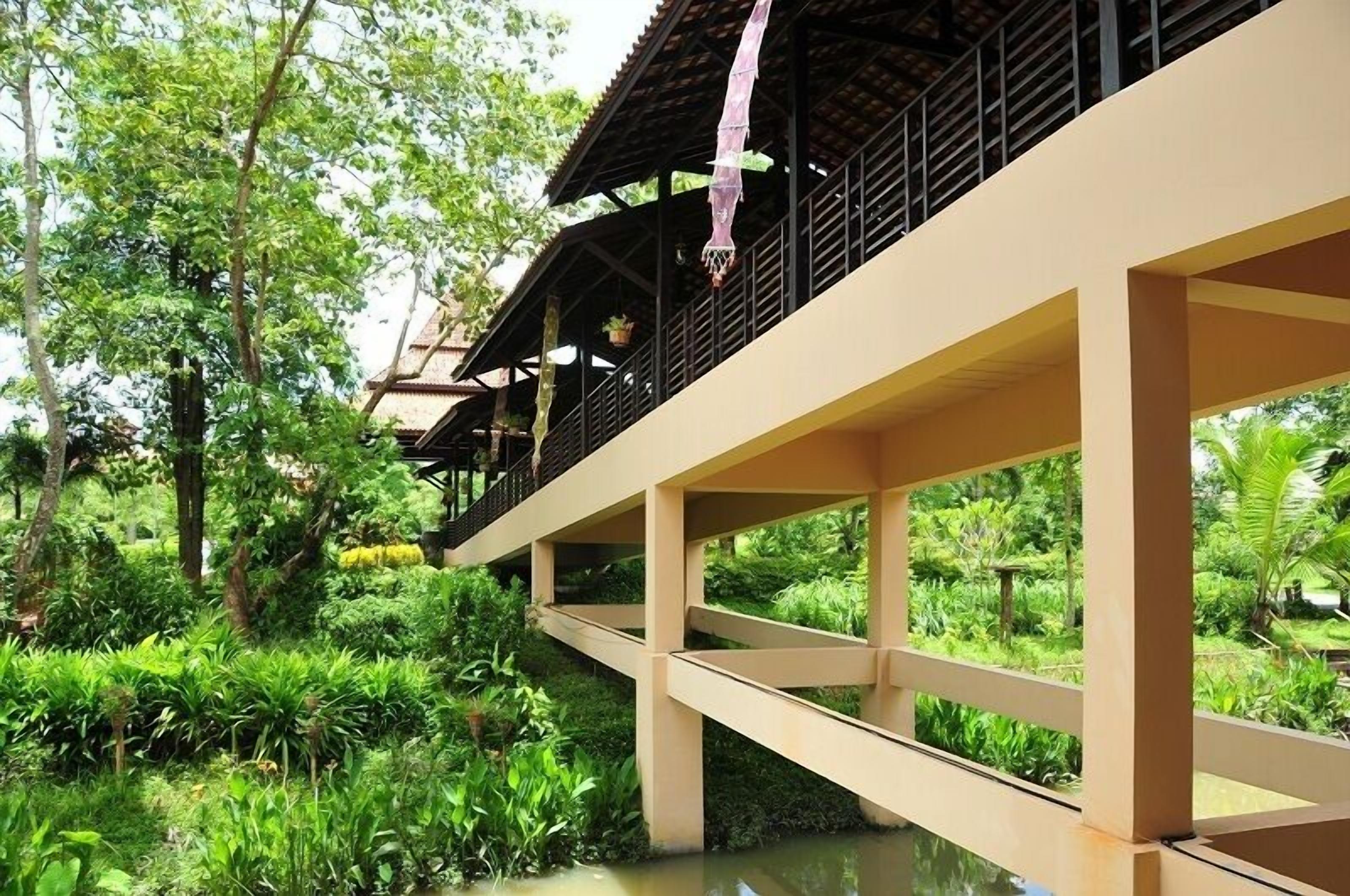 A building with a balcony overlooking lush greenery.