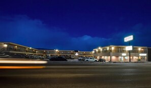 Un hotel con varias edificaciones, un estacionamiento y un letrero que dice 'COAST Suites'.