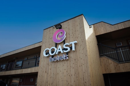 A building with a wooden facade and a sign that reads 'COAST hotels'.