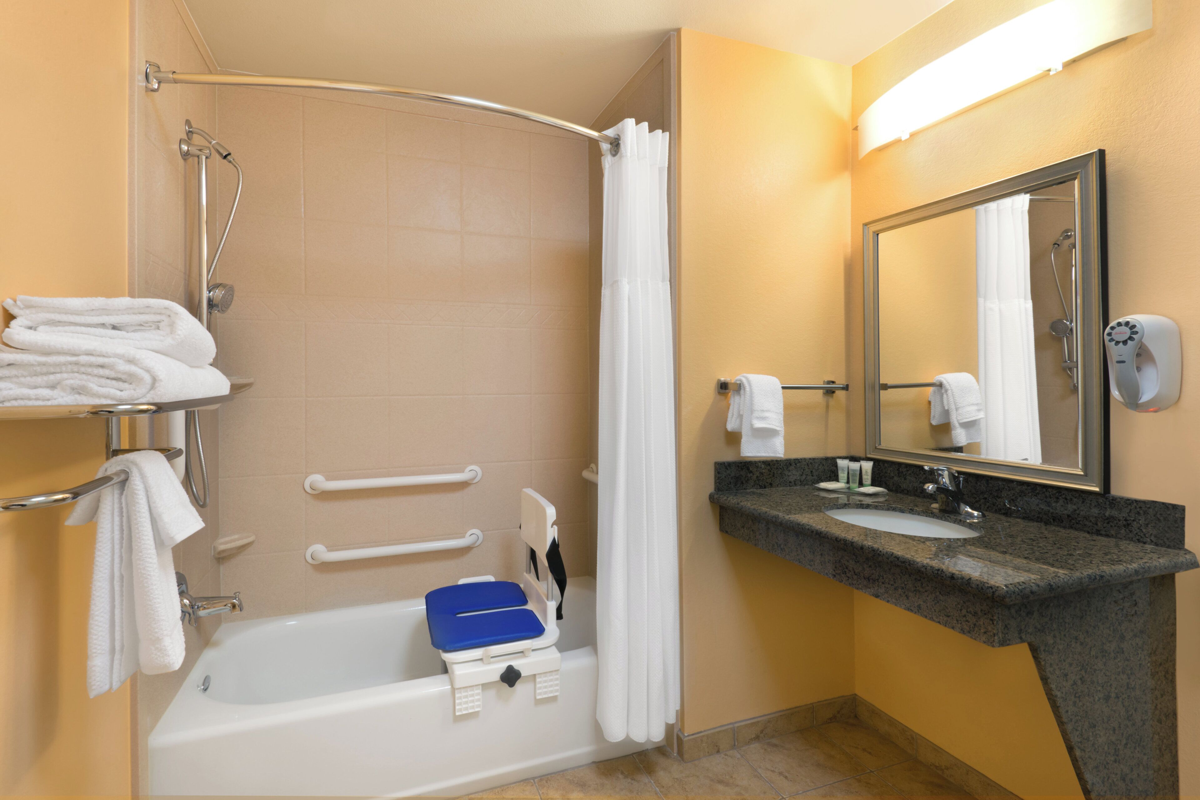 A bathroom with a bathtub, a shower, a sink, and a mirror.