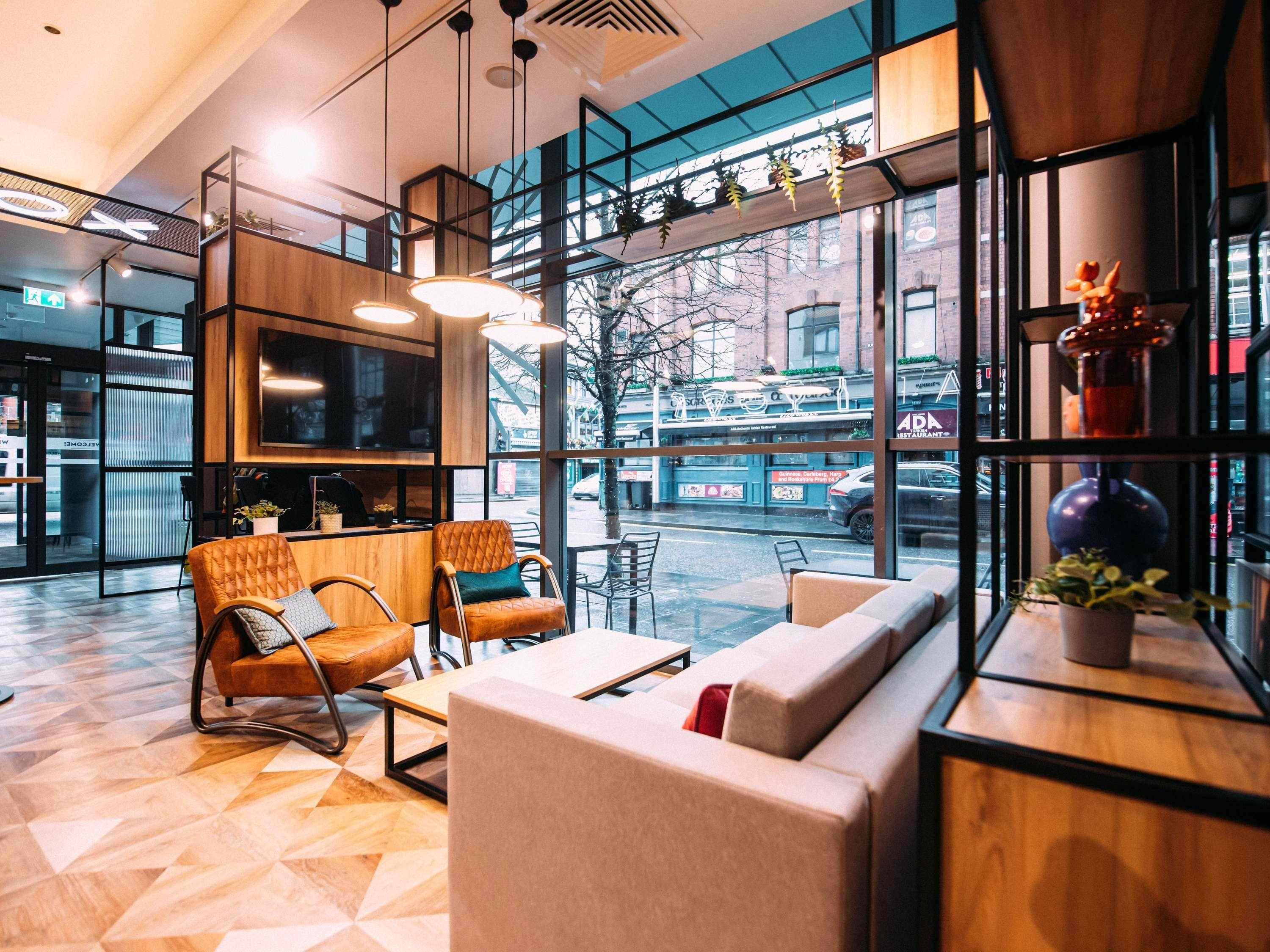 A modern interior with seating, a TV, and large windows.