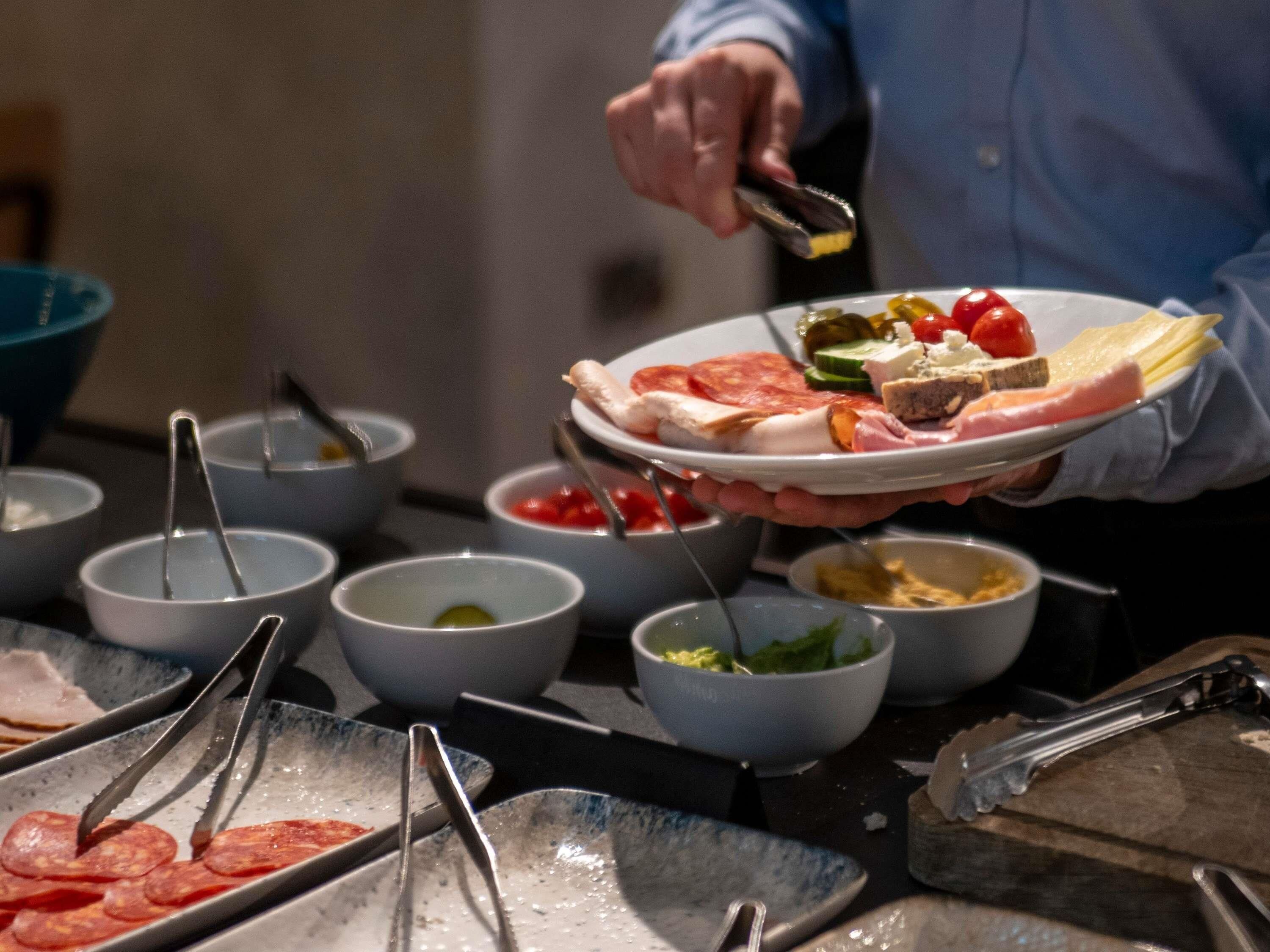 A buffet setup with various food items and utensils.