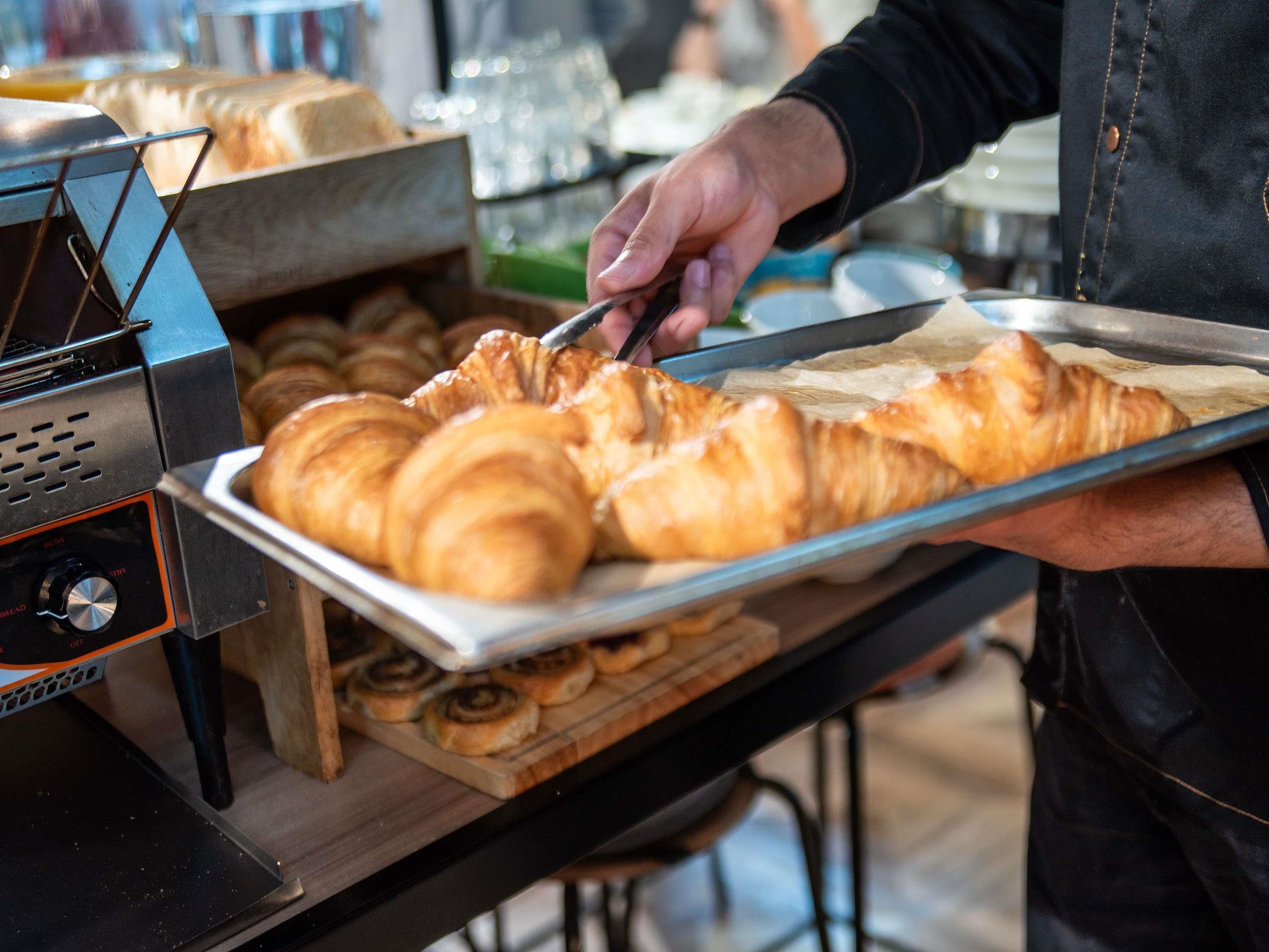 Una persona servint croissants d'una safata.