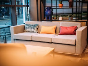 A modern interior with a sofa, a table, and a shelf with decorative items.