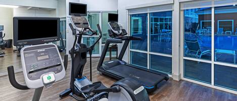 A gym with treadmills, an elliptical, and a stationary bike.