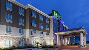 Um hotel Holiday Inn Express com fachada de pedra, várias varandas e entrada coberta.