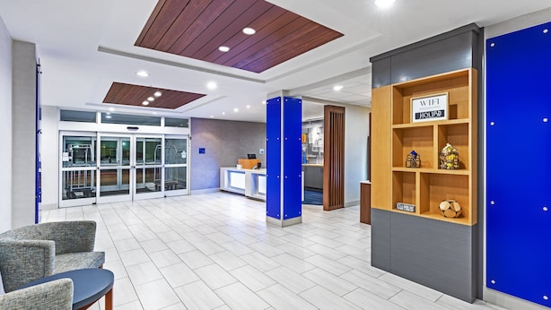 Um hall amplo com balcão de recepção, área de estar e decoração em tons de azul e cinza.