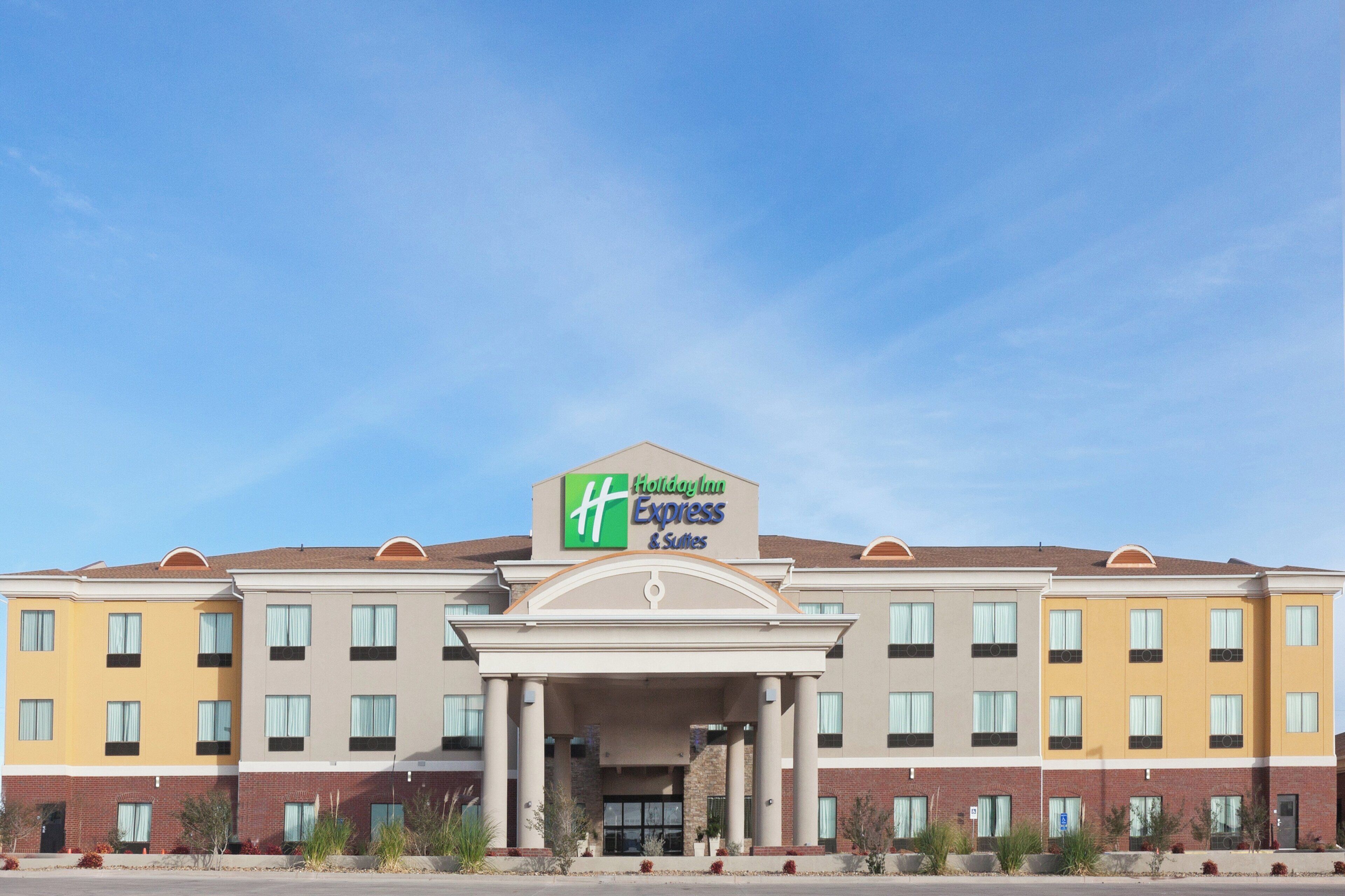 A Holiday Inn Express & Suites hotel with a symmetrical facade, multiple windows, and a central entrance.