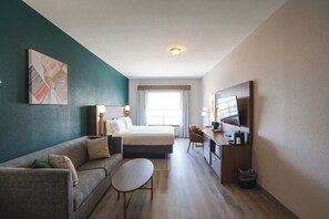 A modern hotel room with a bed, a sofa, a desk, and a TV. - Holiday Inn Hou Energy Corridor Eldridge by IHG (Houston)