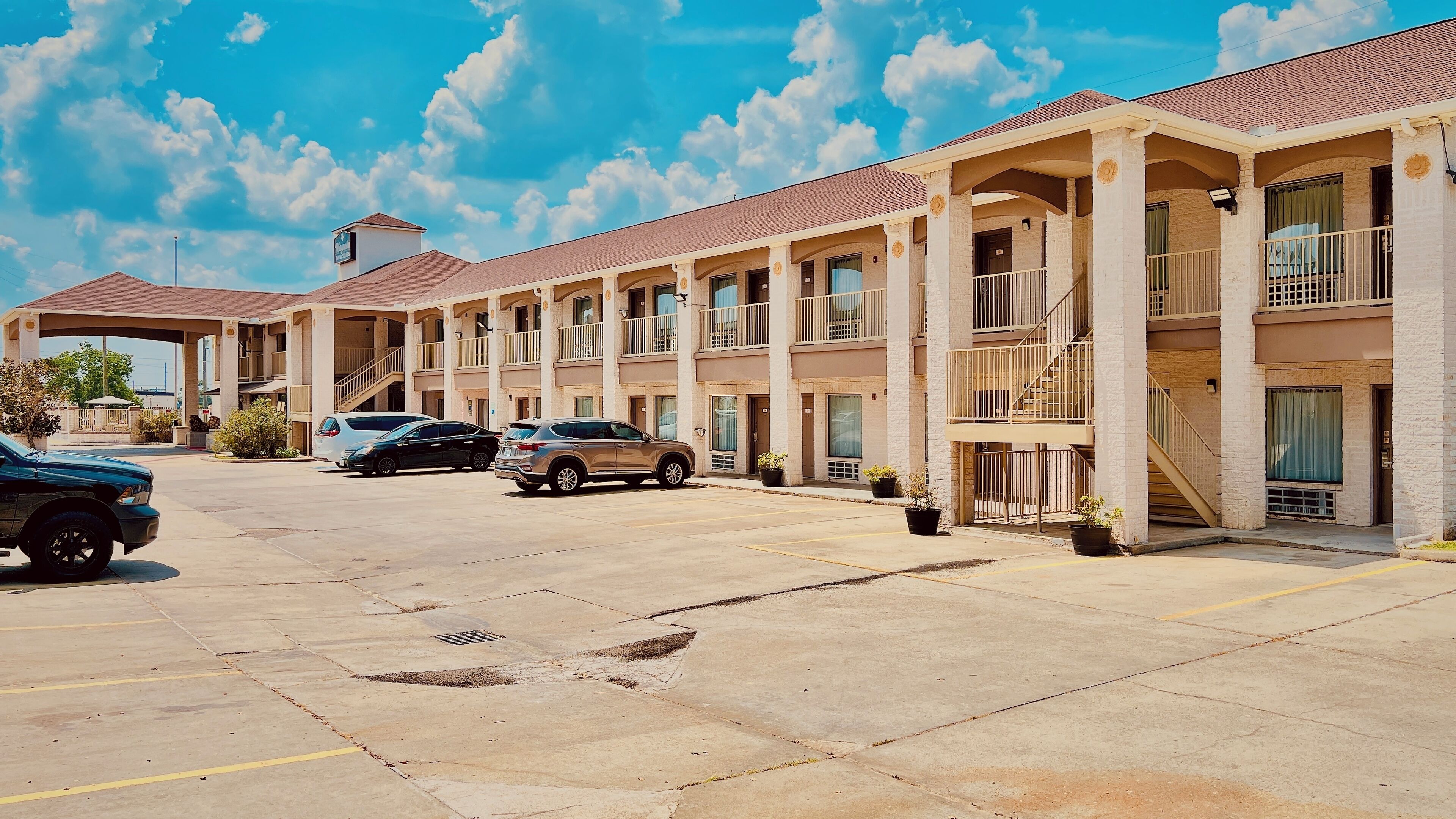 A motel with multiple floors, outdoor parking, and a covered entrance.
