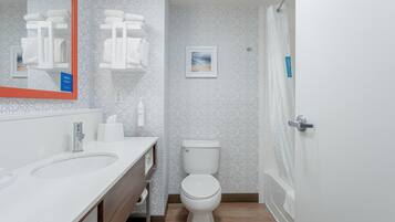Une salle de bain moderne avec un lavabo blanc, des toilettes et un espace douche.