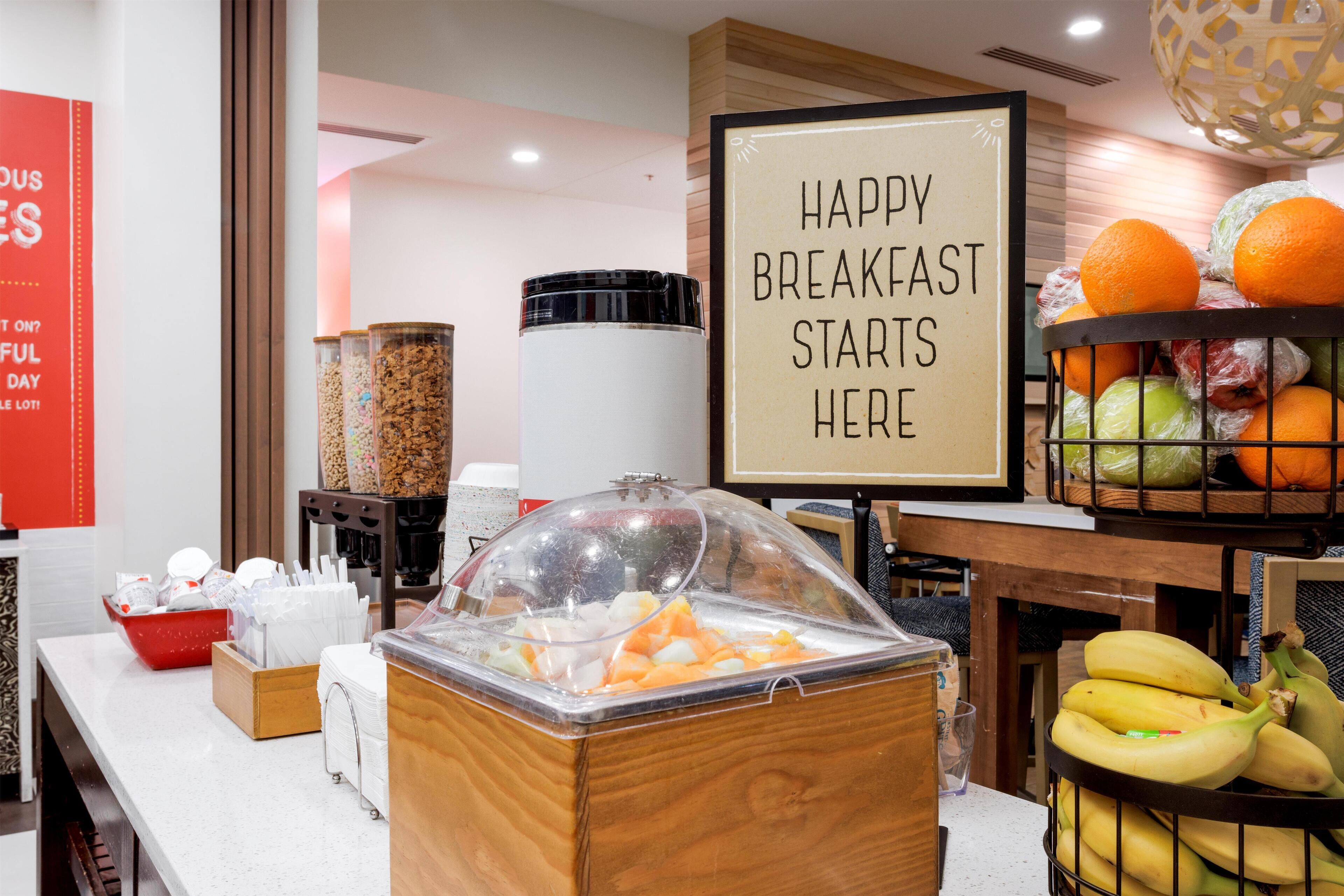 Un espace buffet pour le petit-déjeuner avec une pancarte indiquant : « C’EST ICI QUE COMMENCE UN PETIT-DÉJEUNER RÉUSSI ».