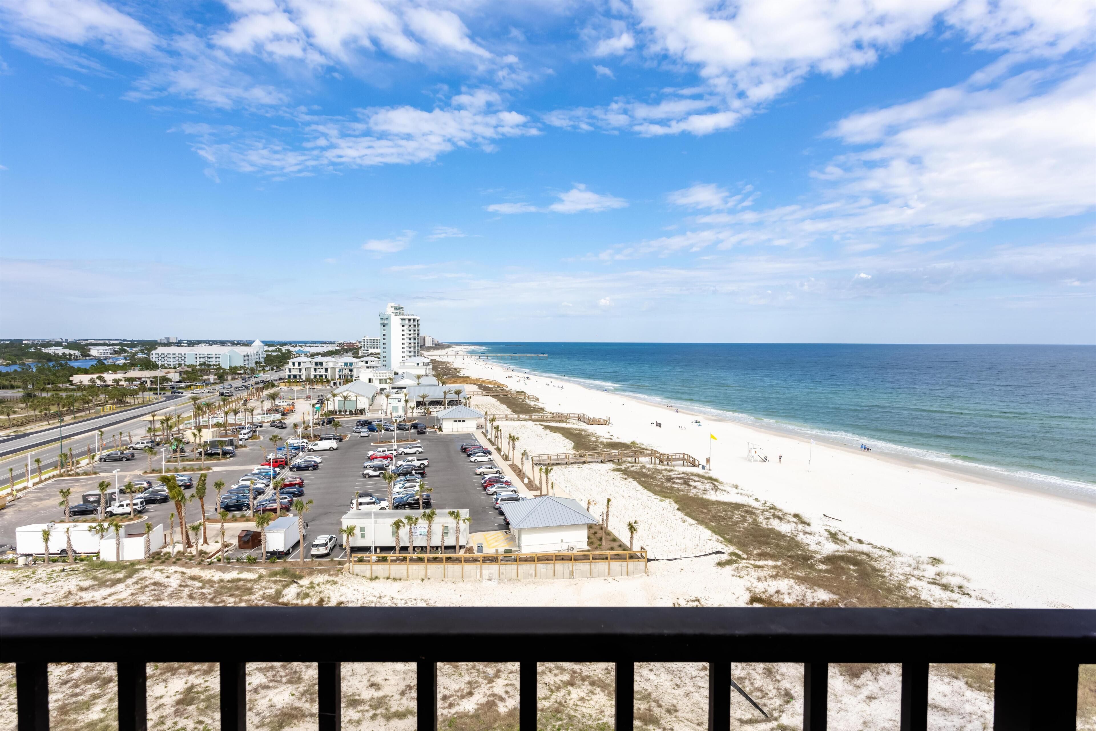 A beachside view with a parking lot, beach, and ocean.