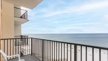 A balcony with a view of the beach and ocean.