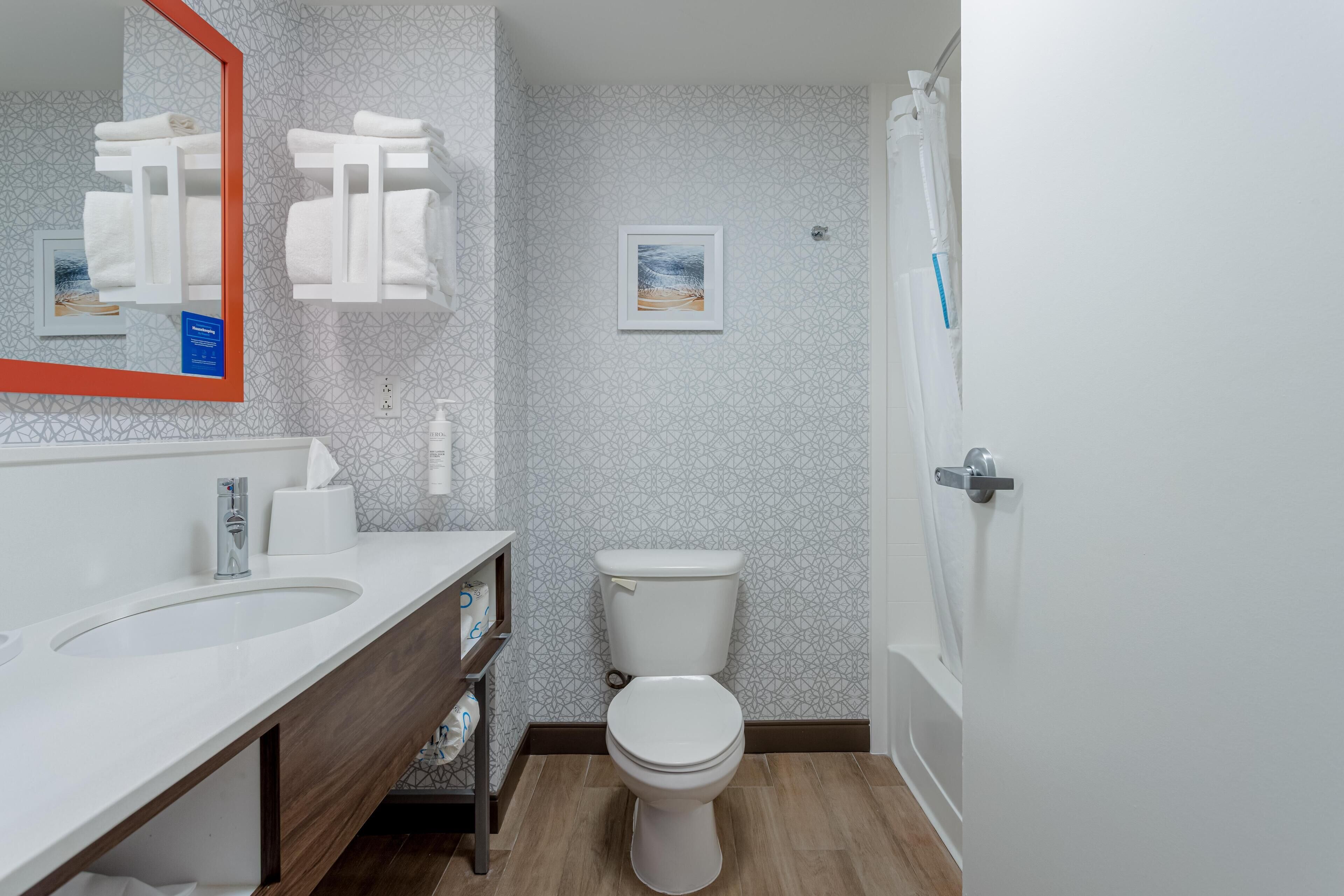 Ein modernes Badezimmer mit Waschbecken, Toilette und Duschbereich.