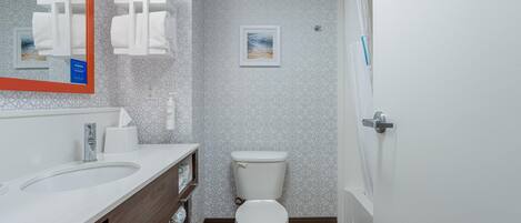 Ein modernes Badezimmer mit Waschbecken, Toilette und Duschbereich.
