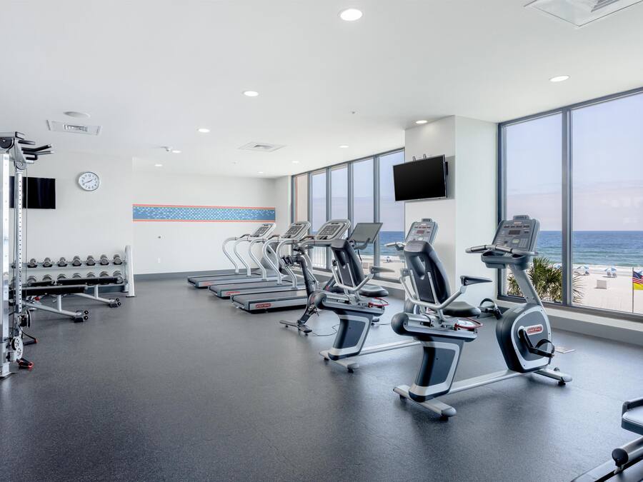 Ein Fitnessstudio mit Laufbändern, Kraftgeräten und Kurzhanteln.