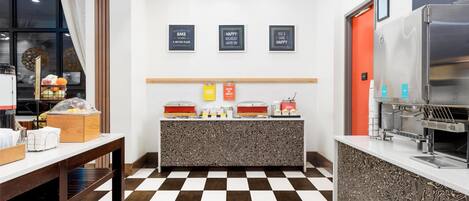 A breakfast bar with a checkered floor, a refrigerator, and a coffee machine.