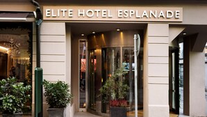 The exterior of the Elite Hotel Esplanade with a clear entrance, potted plants, and a sign above the doors. - Elite Hotel Esplanade (Malmö)