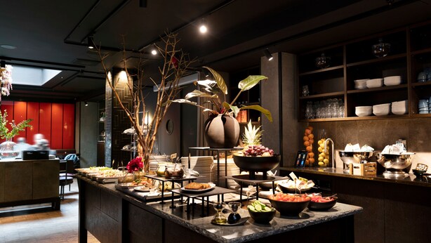 A buffet setup with various food items and a decorative plant arrangement. - Elite Hotel Esplanade (Malmö)