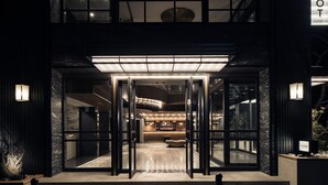 A modern hotel entrance with glass doors, a reception desk, and a well-lit interior. - Hotel The Knot Yokohama (Yokohama)