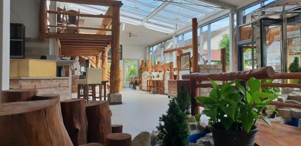 A spacious room with a high ceiling, wooden beams, and a glass enclosure.