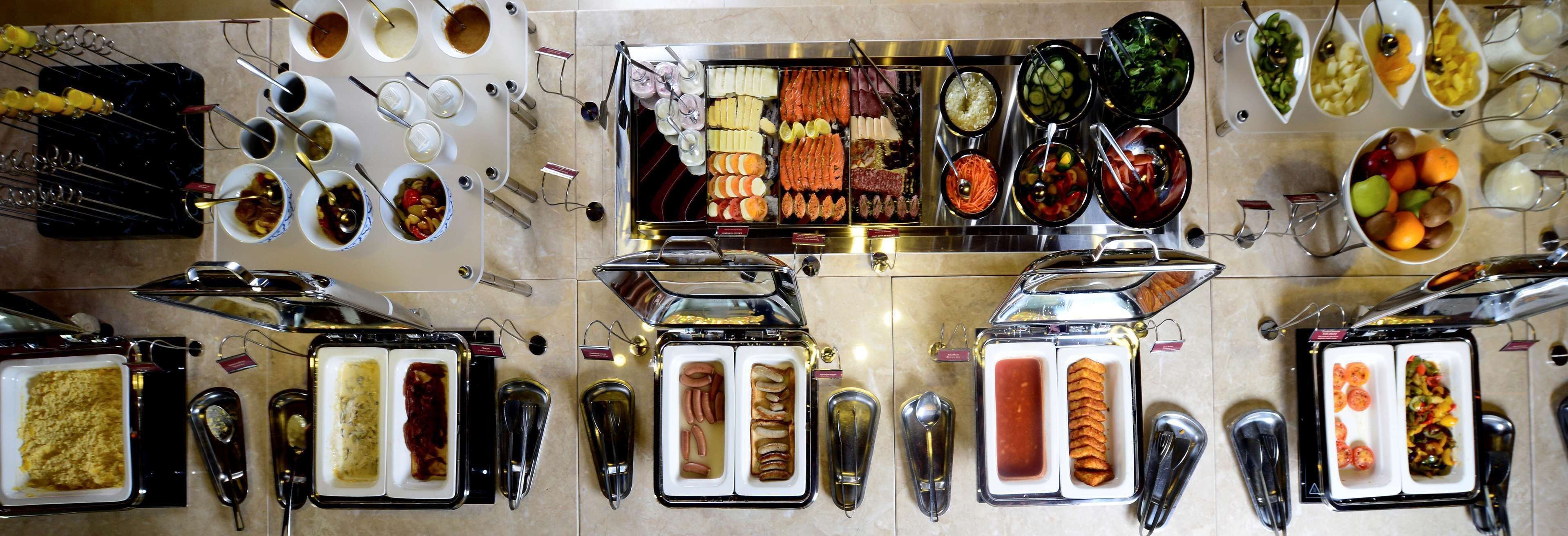 A buffet with various food items and utensils.