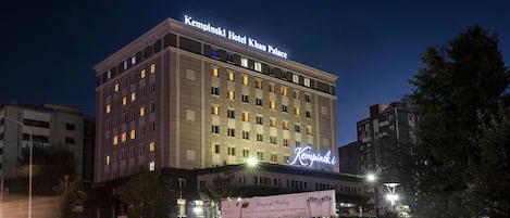 A multi-story hotel with illuminated signage, a prominent entrance, and a surrounding urban environment.