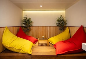 A seating area with wooden paneling, two potted plants, and a small table with a flower vase. - Kempinski Hotel Khan Palace (Ulaanbaatar)