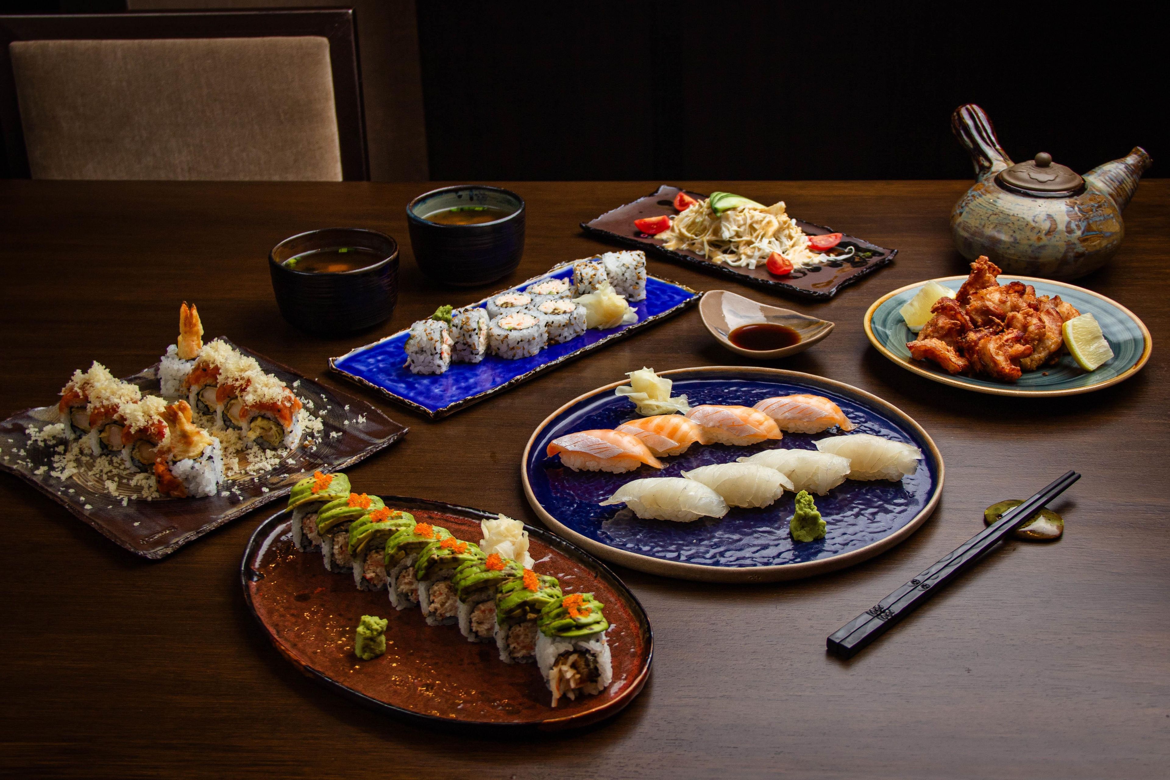 Variedad de platos de sushi sobre una mesa de madera.