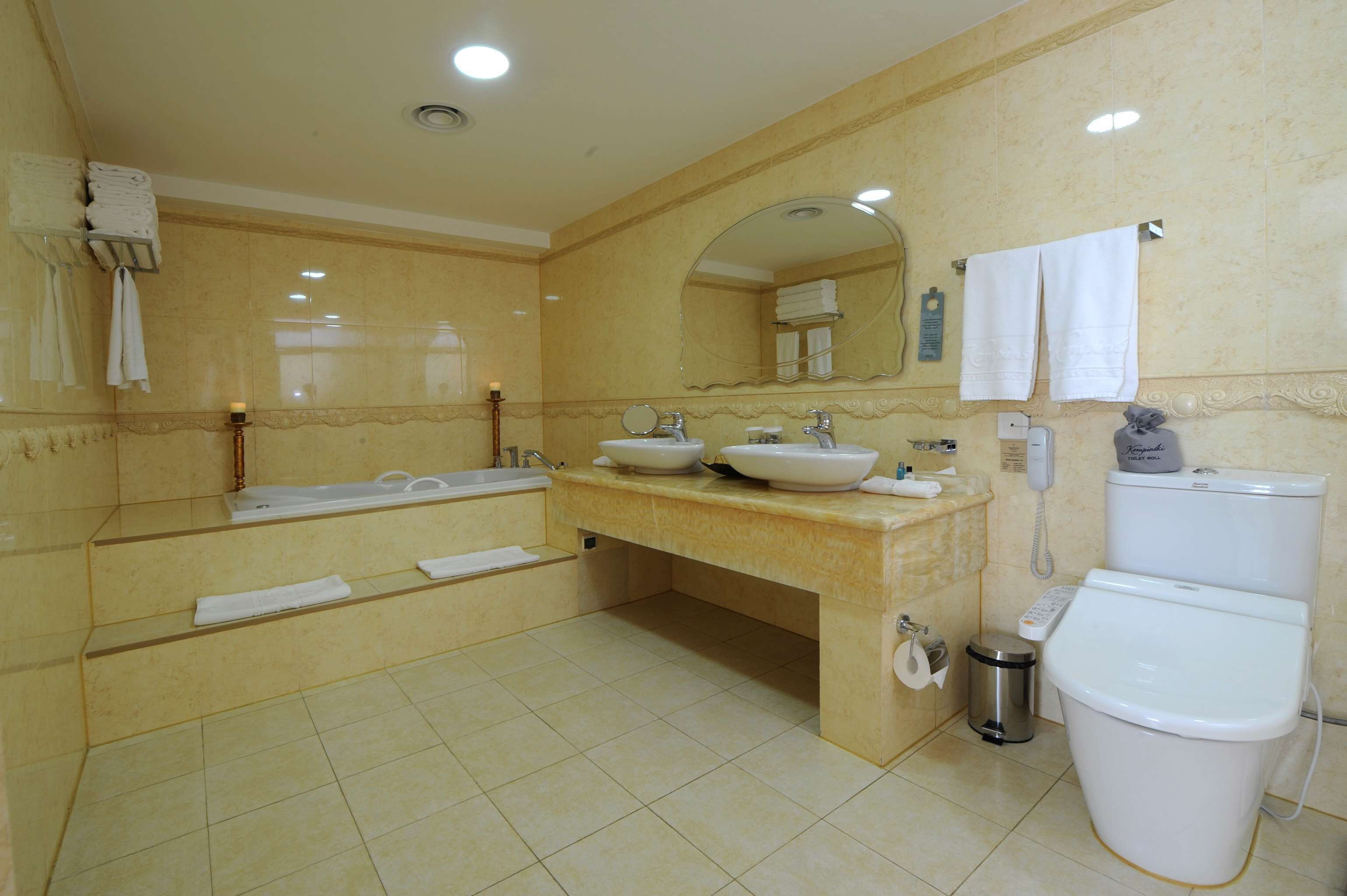 Un baño con dos lavabos, una bañera, un inodoro y un espejo.