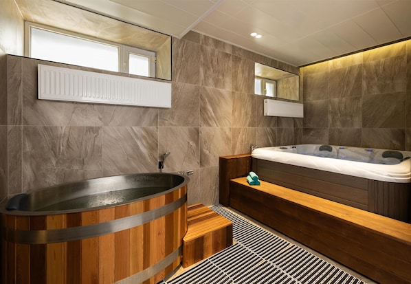 A modern bathroom with a wooden bathtub, a wooden bench, and a large mirror. - Kempinski Hotel Khan Palace (Ulaanbaatar)