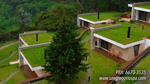 Um hotel moderno com telhados planos e paisagem verde exuberante.
