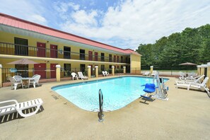 A hotel with a swimming pool, multiple balconies, and outdoor seating. - Red Roof Inn Cartersville–Emerson/LakePoint North (Cartersville)
