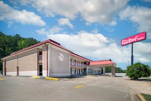 A Red Roof Inn with a two-story building, a covered parking area, and a clear sky. - Red Roof Inn Cartersville–Emerson/LakePoint North (Cartersville)