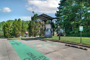 A parking area with electric vehicle charging stations, marked spaces, and a canopy structure. - Red Roof Inn Cartersville–Emerson/LakePoint North (Cartersville)