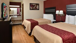 Une chambre d’hôtel avec deux lits, une télévision, une salle de bain et un tableau au mur.
