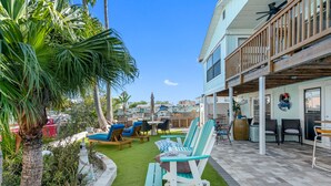 A patio with outdoor seating, a pool, and a building with a balcony. - Sand Vista Vacation Rentals (Redington Shores)