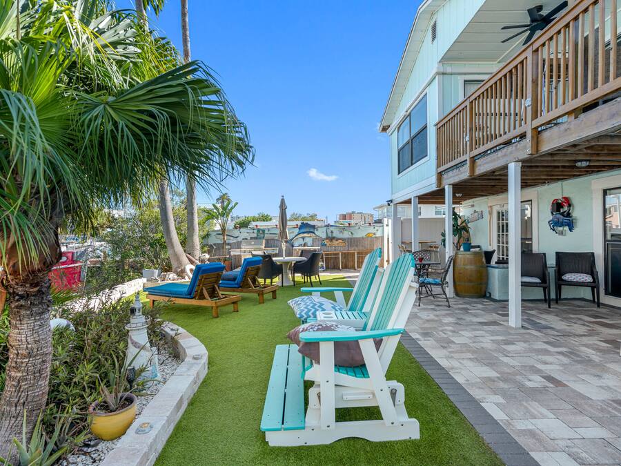 Eine Terrasse mit Außenmöbeln, ein Pool und ein Gebäude mit einem Balkon.