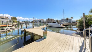 A marina with docked boats, wooden walkways, and a clear blue sky. - Sand Vista Vacation Rentals (Redington Shores)
