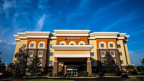 A multi-story hotel with a prominent entrance, a clear sky, and surrounding greenery. - Best Western Plus Goodman Inn & Suites (Horn Lake)