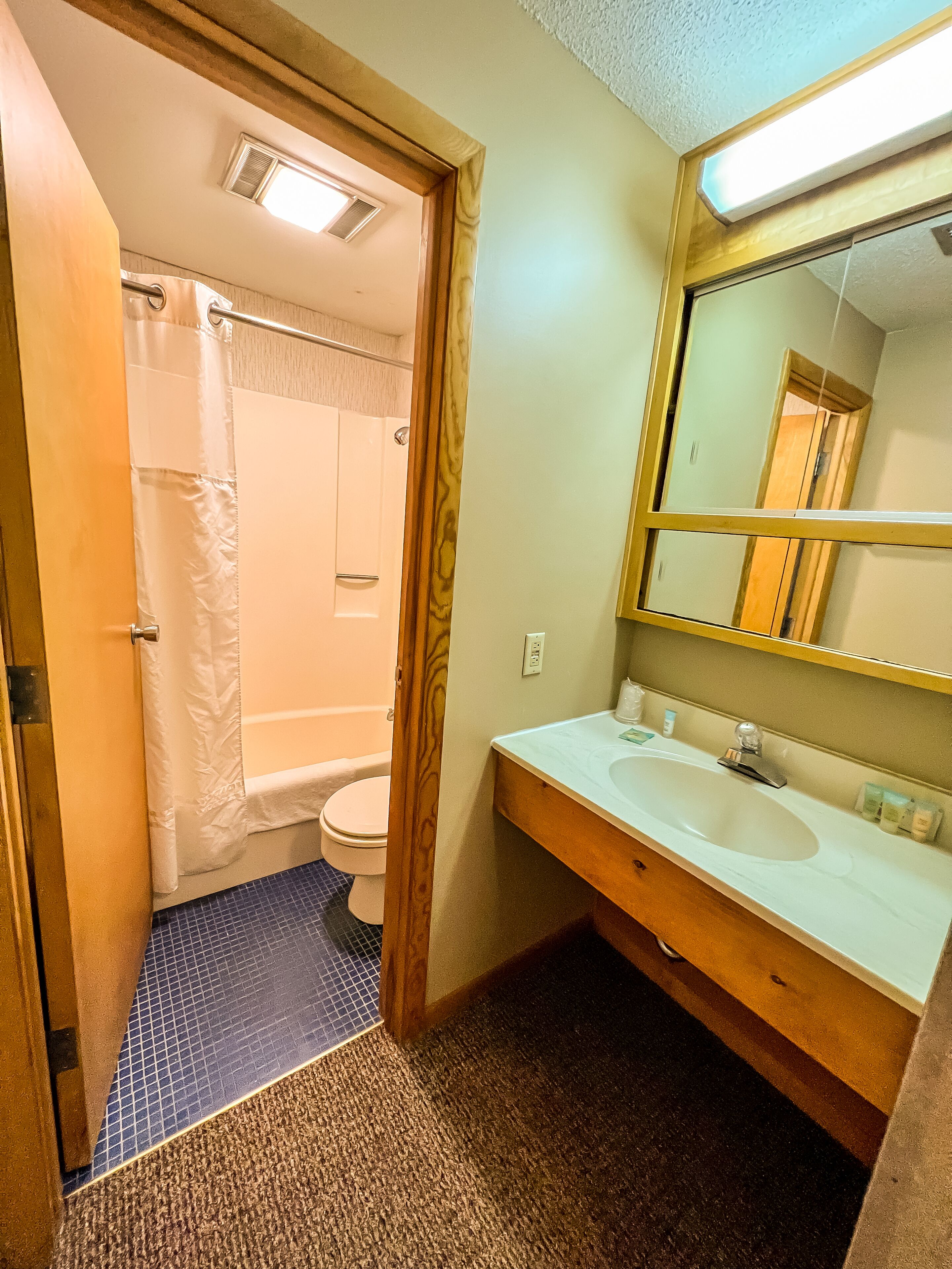 A bathroom with a shower, toilet, and sink.