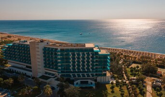 Un hotel grande con varios pisos y balcones con vistas a la playa.