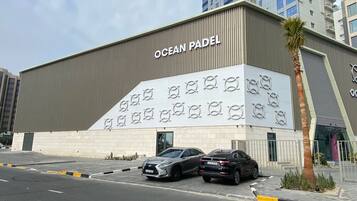 Un edificio moderno con el letrero "OCEAN PADEL" y una fachada distintiva con patrones circulares.