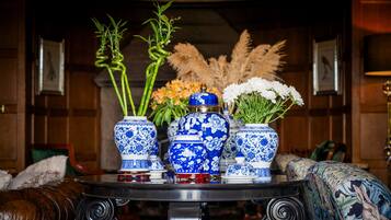 Un tavolo con tre vasi blu e bianchi decorati: uno con bambù e l'altro con fiori bianchi.