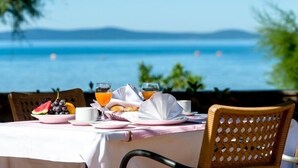 A table set for breakfast with a view of the sea.