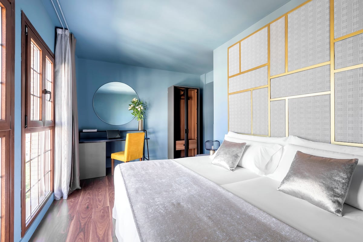 Un dormitorio con cama, escritorio, silla y armario.