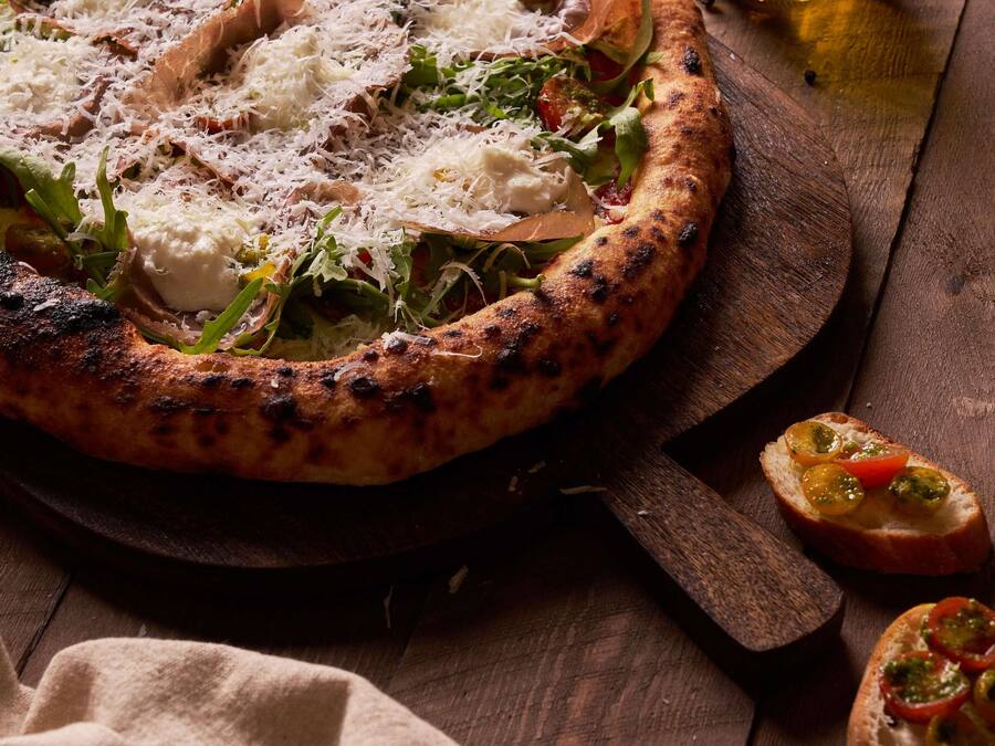 Pizza com cobertura em tábua de madeira.